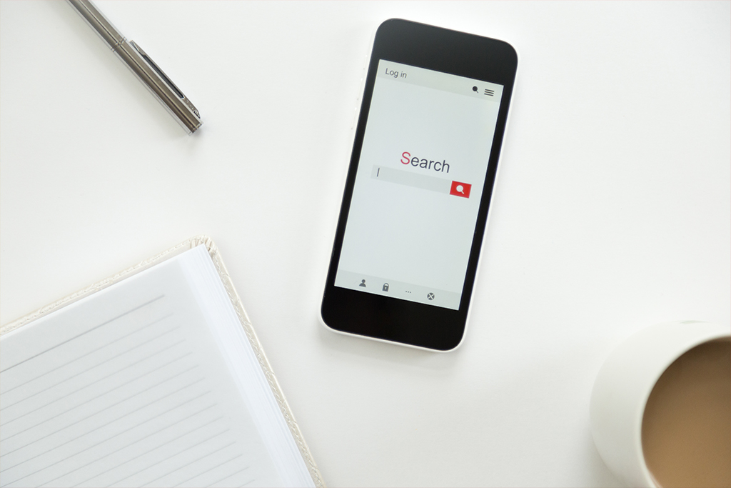 An image of a mobile devices with a search engine browser open on the screen